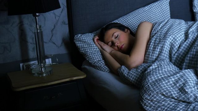 A beautiful woman sleeping alone in bed