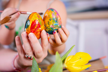 Colorful easter eggs decorated by little hads of girl and woman. Traditional handcraft for Happy...