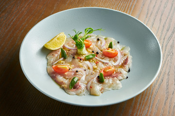 Close up view sea bass ceviche served in white bowl wooden background. Fresh and tasty cebiche. Raw fish. Latin America cuisine. Noise grain on post