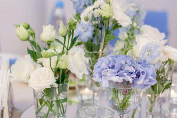 Blue and white flowers in glass vases close-up