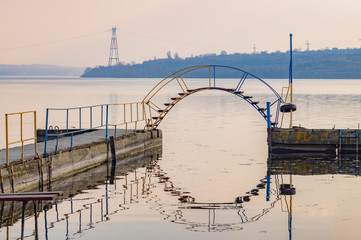footbridge on old pier reflected in water