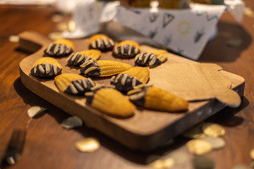 petite Madeleines decorated like bear paws with chocolate and almonds on a table.