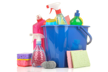 Various bottles with cleaning products and detergents in a blue bucket on a white isolated background.