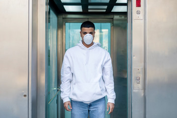 Front view portrait of a young male wearing protective facial mask against transmissible infectious diseases and as protection against the flu or coronavirus in public place.