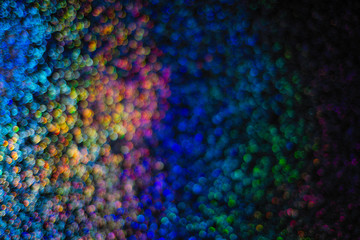 abstract disfocused multi-color bokeh on Black sparkling background . Holiday background.