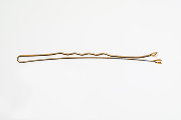 Single brass hair pin horizontal macro shot isolated on white background