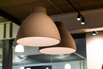 Indoor bar light fixtures  round grey hanging from the ceiling low angle view - Powered by Adobe