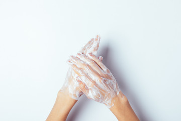 Female's hands in soap suds on white background