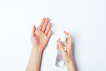 Woman's hands applying alcohol disinfectant spray