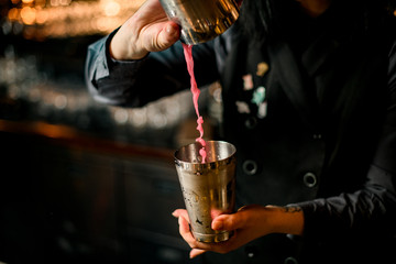 close-up of how bartender pouring cocktail using shaker