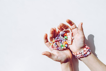 bead bracelets. beads in the hands. decorations. bijouterie. hobbies of girls. rings. background