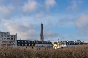 View on the Eiffel Tower in Paris between city buildings.