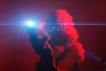 Girl with blaster in the futuristic battle. Concept virtual reality, cyber game. Image with glitch effect.