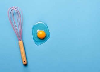 Baking concept with a whisk and egg yolk