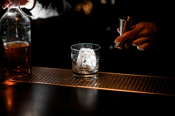 bartender preparing to make cold alcoholic cocktail.