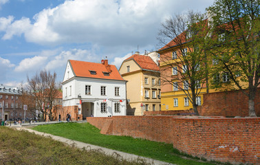 Warsaw Old city. Houses and city wall. Earthworks. Red brick city wall. Small street, Rycerska street, in the medieval old city in Warsaw. The oldest historical district of Warsaw