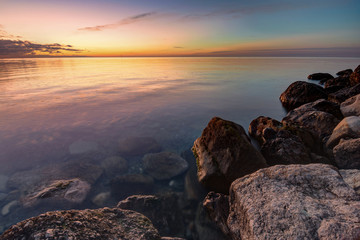 Calm beautiful evening seascape, in the foreground huge stones