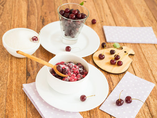 Berries. Cherry with sugar on a small wooden cutting board