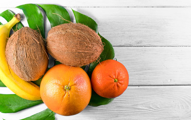 tropical fruits on a palm leaf on a gray background