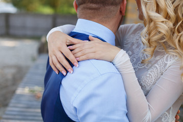 wedding day. newlyweds holding hands on marriage ceremony. passionate hugs of a loving couple.  happy man and blonde woman gently hugging. wedding romantic moment close up. romantic date outdoors. 