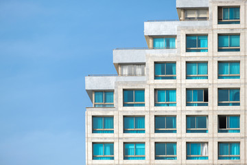 a fragment of a modern building against the blue daytime sky. the building is built on the principle of stairs.