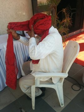 Side View Of Man Wearing Turban While Sitting On Chair