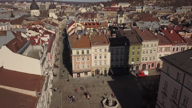 Aerial view to historic and tourist center of Lviv city from above. Roofs of historic buildings and roads with tourist on it, Ukraine