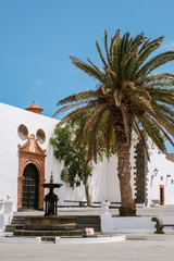 Fototapeta na wymiar Main square in in Teguise with palm and fountain. An historic village in Lanzarote, Canary Islands, Spain