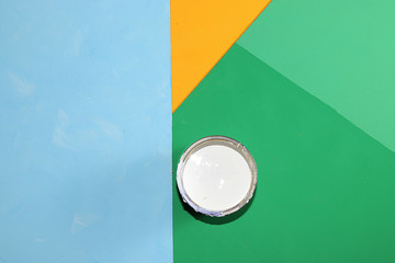 Can of paint for repair on a multi-colored painted background. Banner for the shop, geometry....
