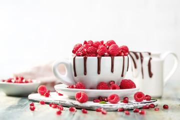 Raspberry mug cake in a white ceramic mug on white background
