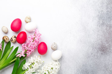 Easter composition. Green mint plate, easter eggs, pink and white hyacinth on stone background. Copy space. Top view