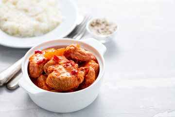 baked turkey meat in white bowl and boiled rice on white plate