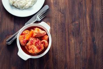 baked turkey meat in white bowl and boiled rice on white plate