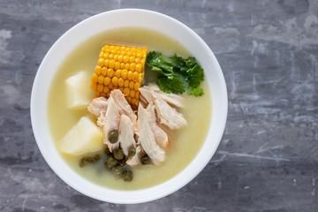 soup potato with corn and chicken in white bowl on ceramic background