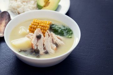 soup potato with corn and chicken in white bowl on ceramic background