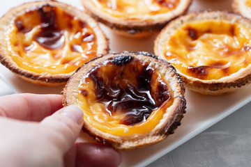 typical portuguese sweets pastel de nata on white dish on ceramic background