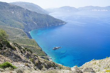 Deep azure Mediterranean sea with misty hills and shoreline of the Greek islands