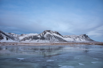 Frozen lake with snow covered mountains in Iceland 