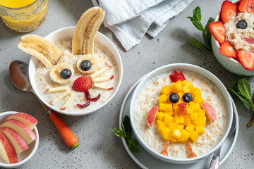 Funny bowls with oat porridge with bunny, chick and flower for Easter
