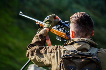 Hunter man. Shooter sighting in the target. Hunting period. Male with a gun. Close up. Hunter with...