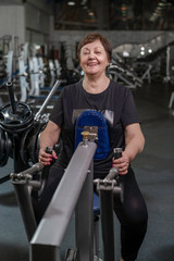 elderly woman goes in for sports in a fitness club