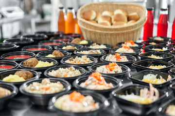 Row of plastic disposable lunch box with healthy natural food. Soups, cream soup, main course with side dish, salads. Food delivery. Lunch in the office.