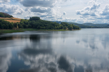 A serene reservoir  with woodland and hills in Morvan National Park, France