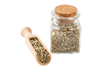 wormwood herb or in latin Absinthii herba herb in a glass jar and wooden scoop isolated on white...