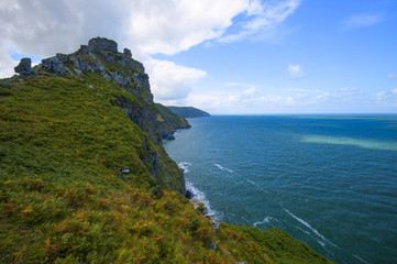 Fototapeta na wymiar Valley of the Rocks, North Devon, with blue sky, clouds and ocean with waves