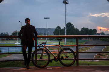 Man and his bike in a park with the cityscape as background