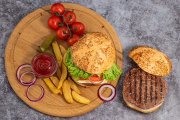 Tasty grilled home made burgers with beef, tomato, cheese, cucumber and lettuce. Top view. Flat lay