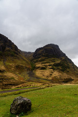 A windswept and overcast view of the Glen Nevis valley with Ben Nevis mountain in the distance.