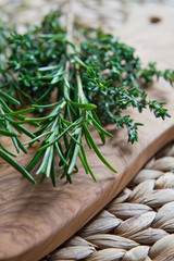 Rosemary and Thyme herbs on the wooden board -  rustic background.