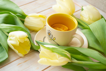 Still life tea drinking with pastel yellow tulips